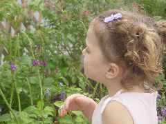 Still trying entice a butterfly to land on her finger.