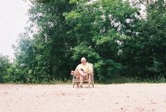 Daddy reading peacefully on the beach.